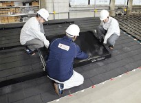 模擬屋根での施工研修例。実際の施工現場では、落下防止のため安全帯の着用が義務づけられています。